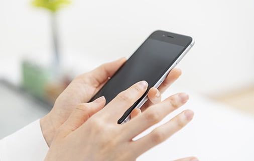 スマホで問い合わせ・予約をしている手元