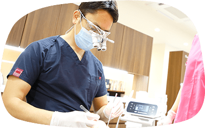 歯科治療する医師