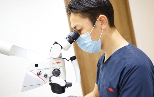 マイクロスコープで処置中の医師